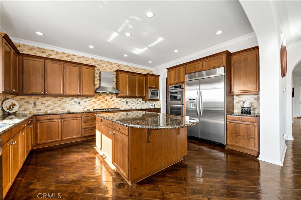 16423 Village Meadow Drive Riverside, CA 92503 - Photo 22 of 63 a kitchen with stainless steel appliances granite countertop a stove top oven a refrigerator a sink and dishwasher with wooden floor