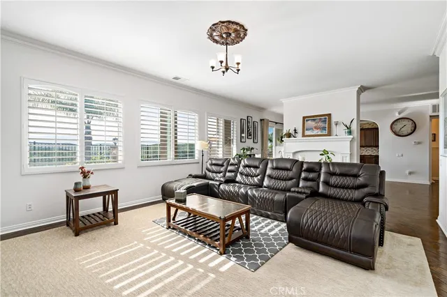 a living room with furniture a chandelier and a window