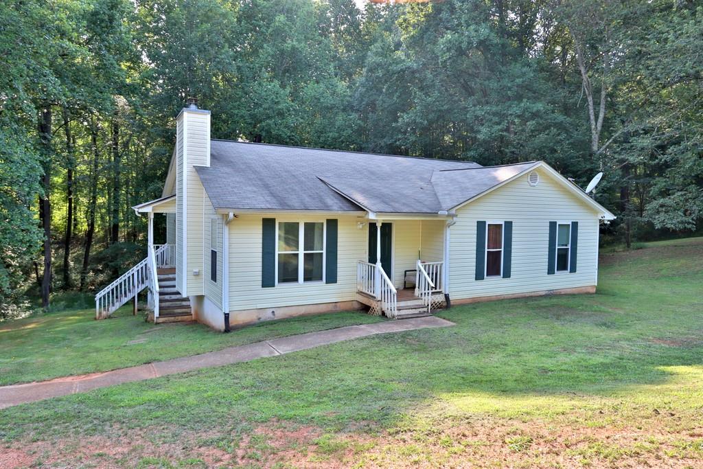 4884 Poplar Springs Road Gainesville, GA 30507 - Photo 1 of 1 a front view of a house with a garden and trees