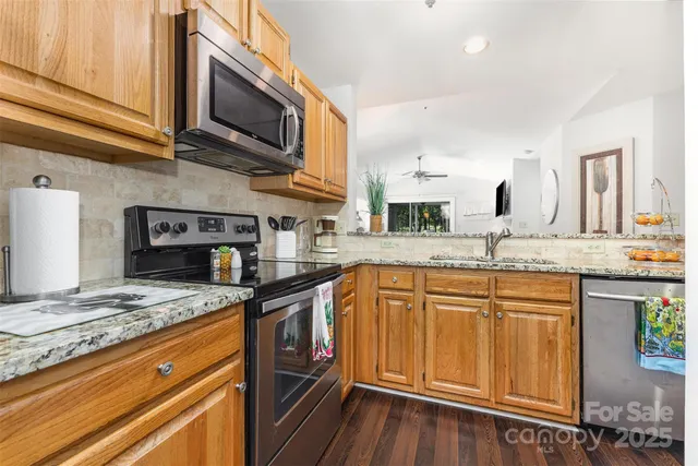 a kitchen with stainless steel appliances granite countertop a sink stove and microwave