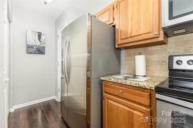 a kitchen with stainless steel appliances granite countertop a refrigerator and a stove top oven