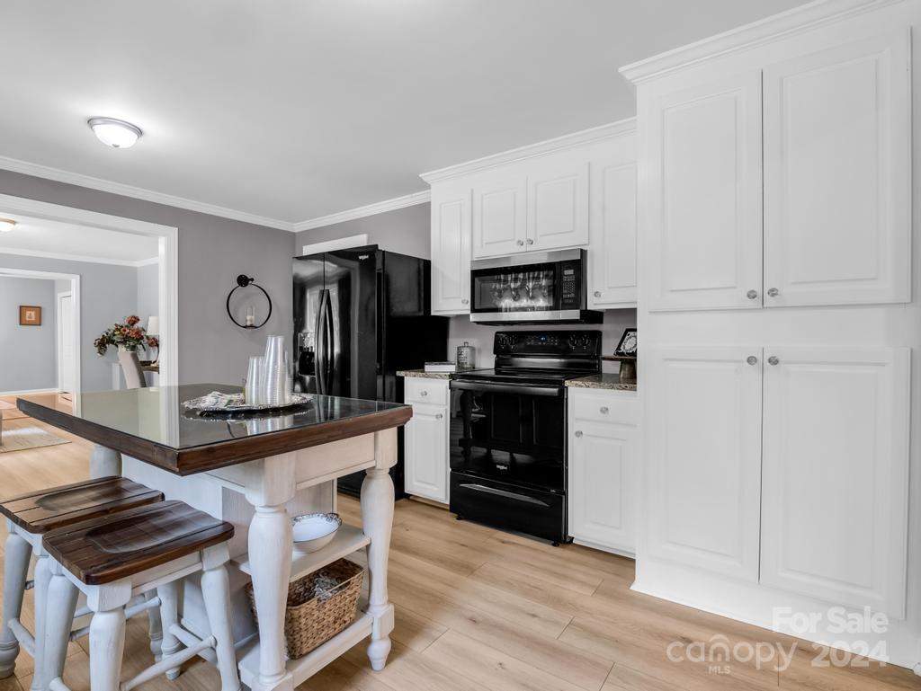 1629 State Line Road Mooresboro, NC 28114 - Photo 7 of 43 a kitchen with kitchen island granite countertop a stove top oven a sink dishwasher and a refrigerator with wooden floor
