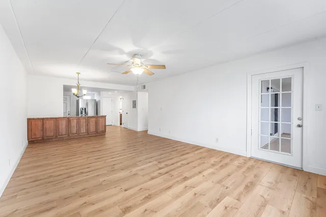 a view of a bedroom with a kitchen and a ceiling fan