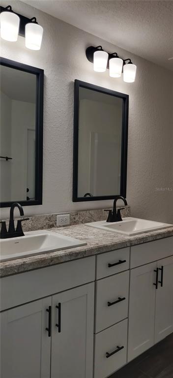 16295 Pomp Parkway Weeki Wachee, FL 34614 - Photo 17 of 28 a bathroom with a double vanity sink and a mirror
