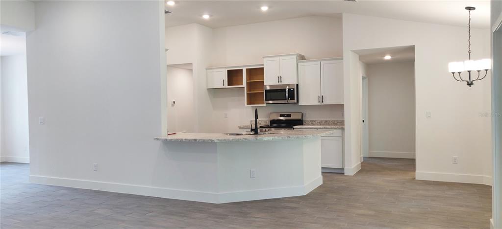 16295 Pomp Parkway Weeki Wachee, FL 34614 - Photo 7 of 28 a kitchen with stainless steel appliances a sink stove and refrigerator