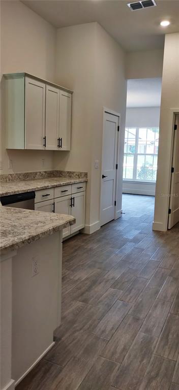 16295 Pomp Parkway Weeki Wachee, FL 34614 - Photo 9 of 28 a kitchen with stainless steel appliances granite countertop a sink cabinets and wooden floor
