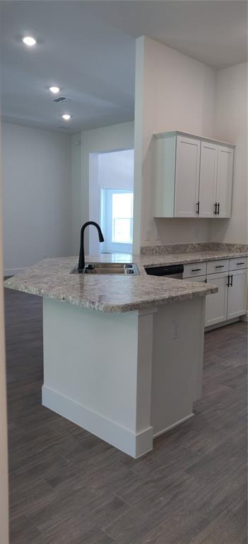 16295 Pomp Parkway Weeki Wachee, FL 34614 - Photo 10 of 28 a kitchen with kitchen island granite countertop a sink cabinets and wooden floor