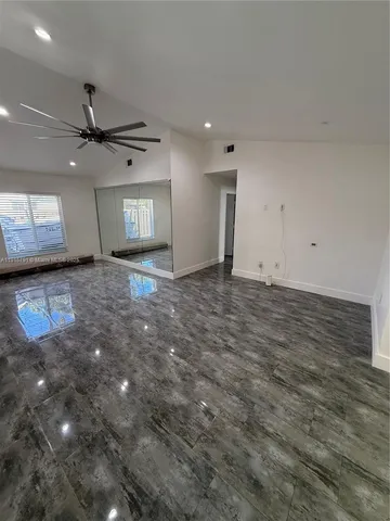 an empty room with fan and windows