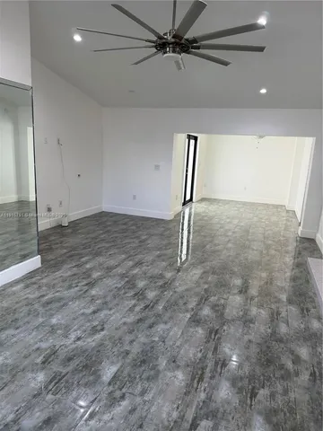 an empty room with a ceiling fan and window