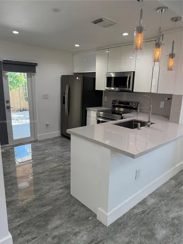 a kitchen with stainless steel appliances a refrigerator sink and microwave