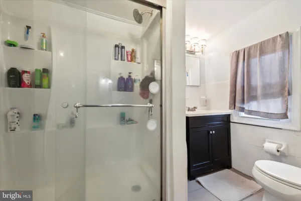a bathroom with a granite countertop sink a toilet and a shower