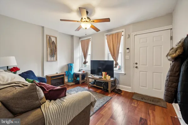 a living room with furniture and a wooden floor