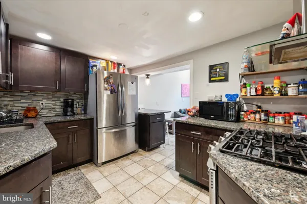 a kitchen with stainless steel appliances granite countertop a stove a refrigerator and a sink