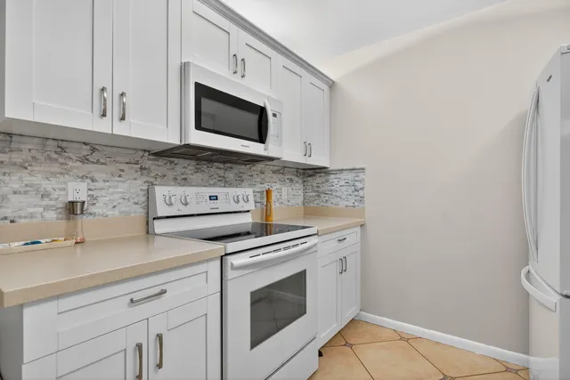 a kitchen with granite countertop white cabinets and stainless steel appliances