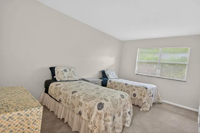 a bedroom with two beds and a night stand