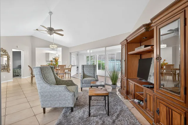 a living room with furniture a flat screen tv and a window