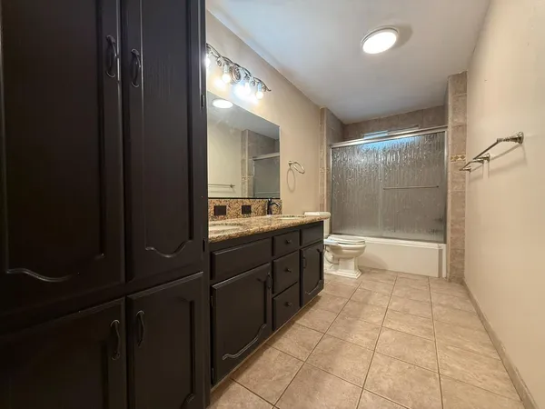 a large bathroom with a glass door shower a sink and a mirror