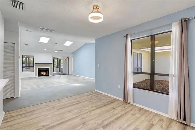 a view of a room with wooden floor and a ceiling fan