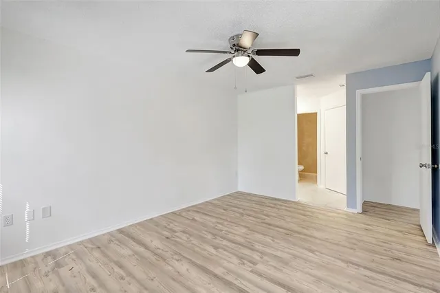 a view of a livingroom with wooden floor and a ceiling fan