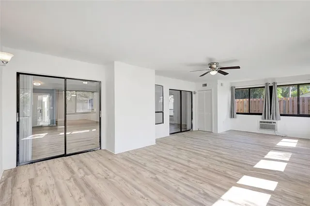 a view of a livingroom with a ceiling fan hardwood floor and a ceiling fan