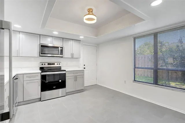 a kitchen with white cabinets and stainless steel appliances