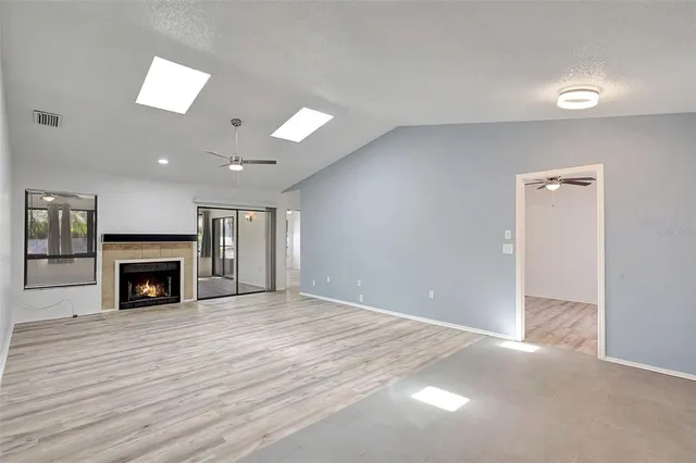 a view of an empty room with a fireplace and a window