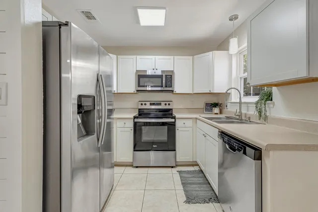 a kitchen with stainless steel appliances granite countertop a refrigerator sink and stove