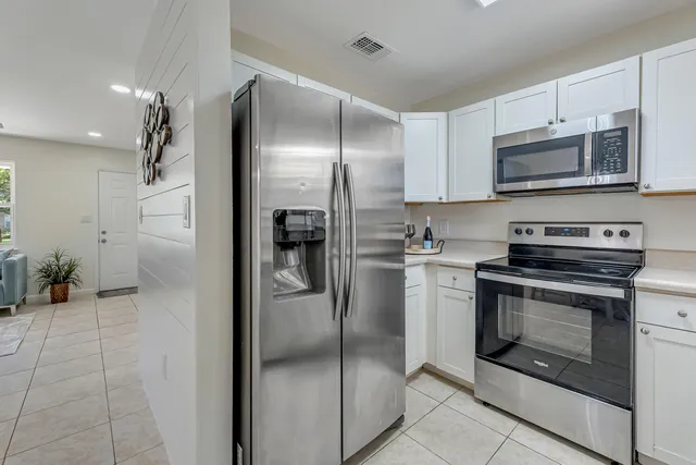 a kitchen with stainless steel appliances granite countertop a refrigerator and a stove top oven