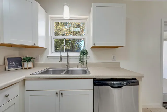 a kitchen with a sink a window and cabinets