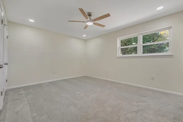 an empty room with a window and a ceiling fan
