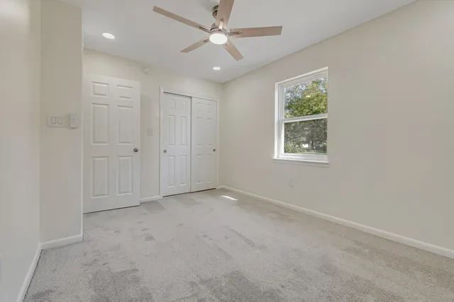 an empty room with a window and a fan