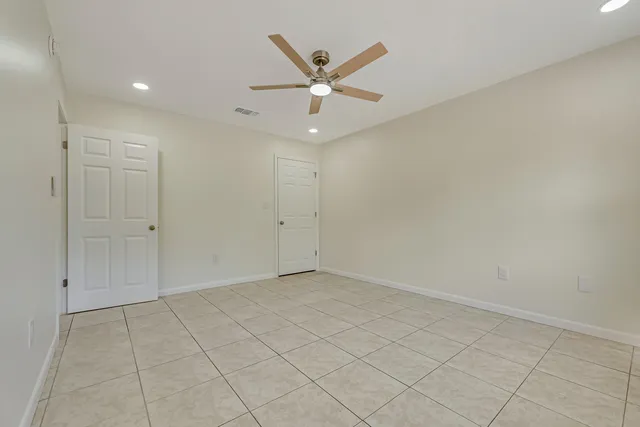 an empty room with closet and ceiling fan