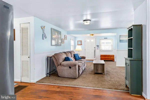 a living room with furniture and a refrigerator