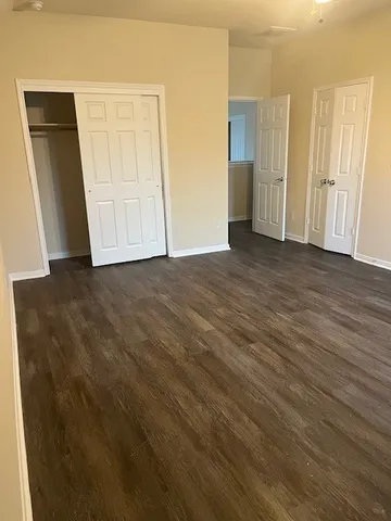 an empty room with wooden floor and closet