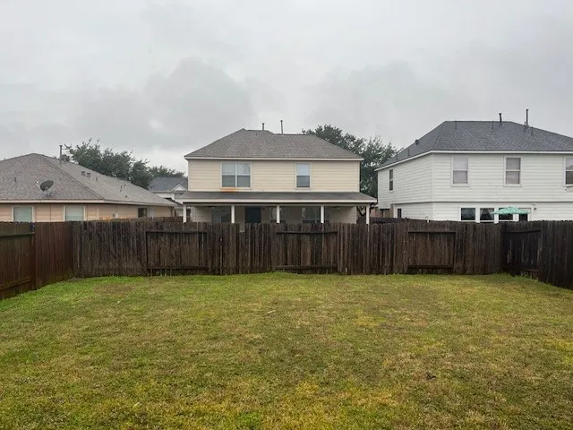 a view of a house with a yard and wooden fence