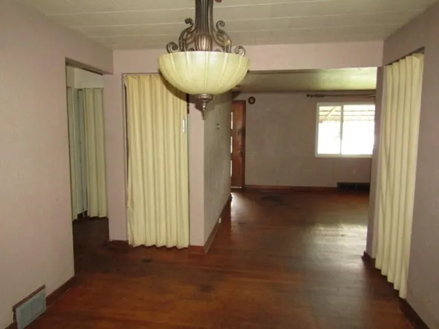 a view of a room with wooden floor and windows