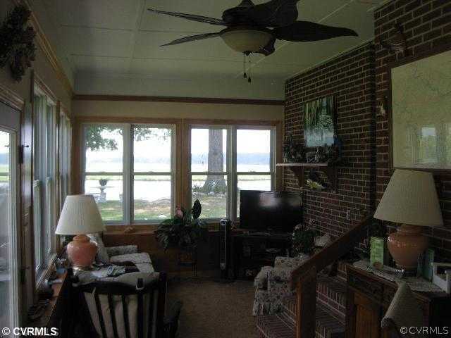 4983 Wakema Road West Point, VA 23181 - Photo 7 of 12 a living room with furniture a flat screen tv and a floor to ceiling window