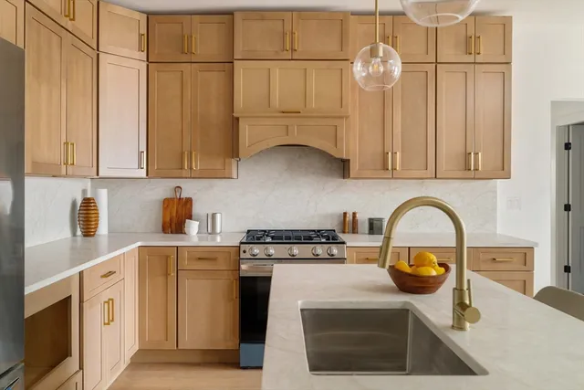 a kitchen with stainless steel appliances granite countertop a stove a sink dishwasher and cabinets with wooden floor