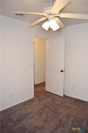 an empty room with a chandelier fan