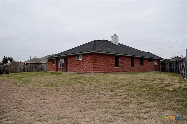 a backyard of a house with wooden fence