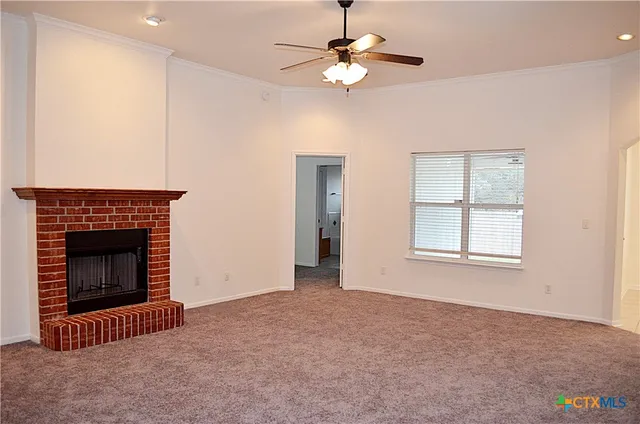 an empty room with windows and fireplace