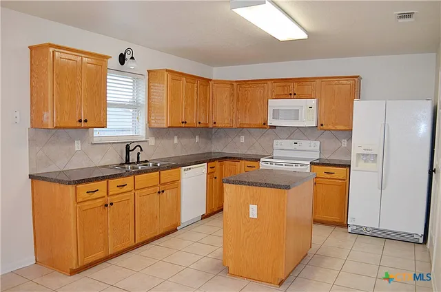 a kitchen with stainless steel appliances granite countertop a sink counter space and cabinets