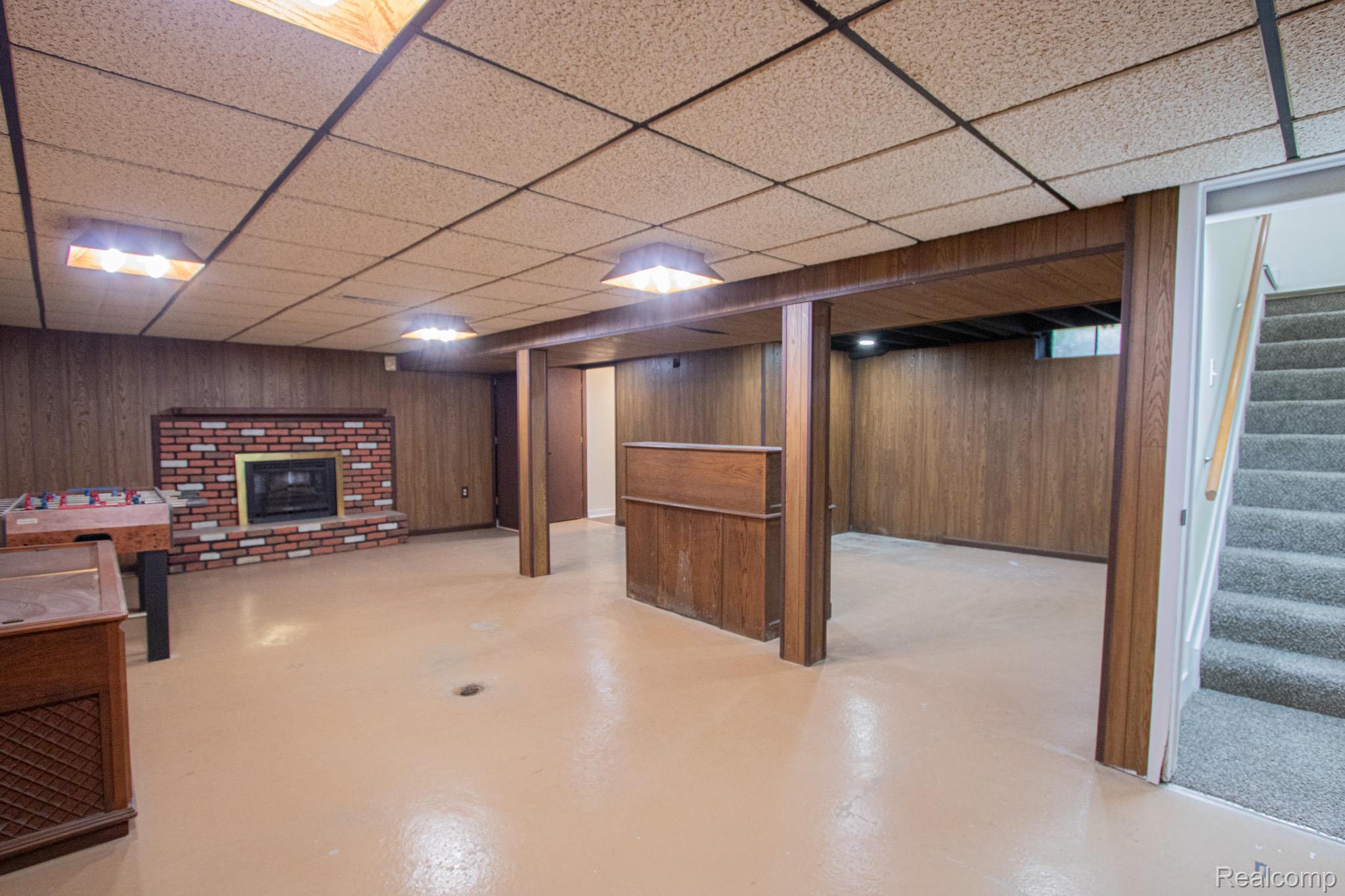 31000 Fall Fraser, MI 48026 - Photo 23 of 28 Finished below grade area with a fireplace, wooden walls, and a paneled ceiling