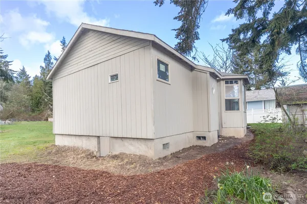 a view of backyard of house with wooden fence