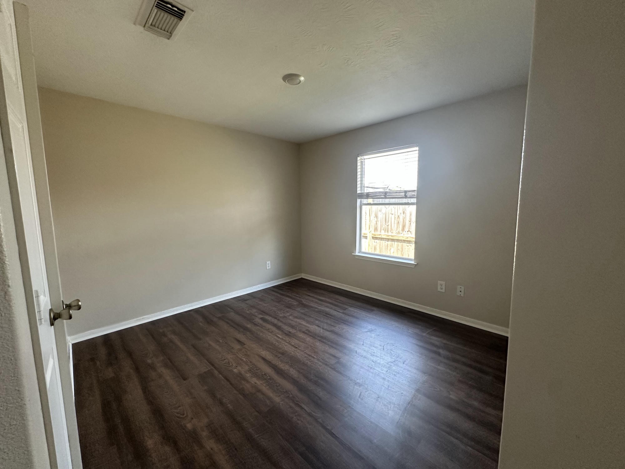 1034 Junction Court Rosenberg, TX 77471 - Photo 11 of 19 an empty room with wooden floor and windows