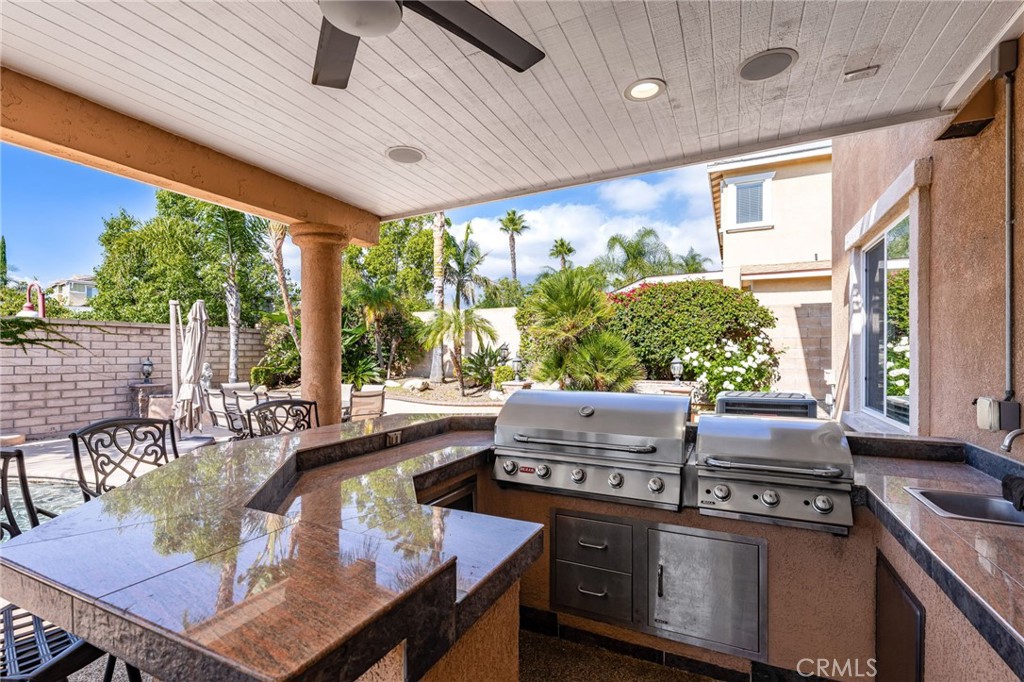 6336 Taylor Canyon Place Rancho Cucamonga, CA 91739 - Photo 42 of 60 a kitchen with a stove a sink and wooden cabinets