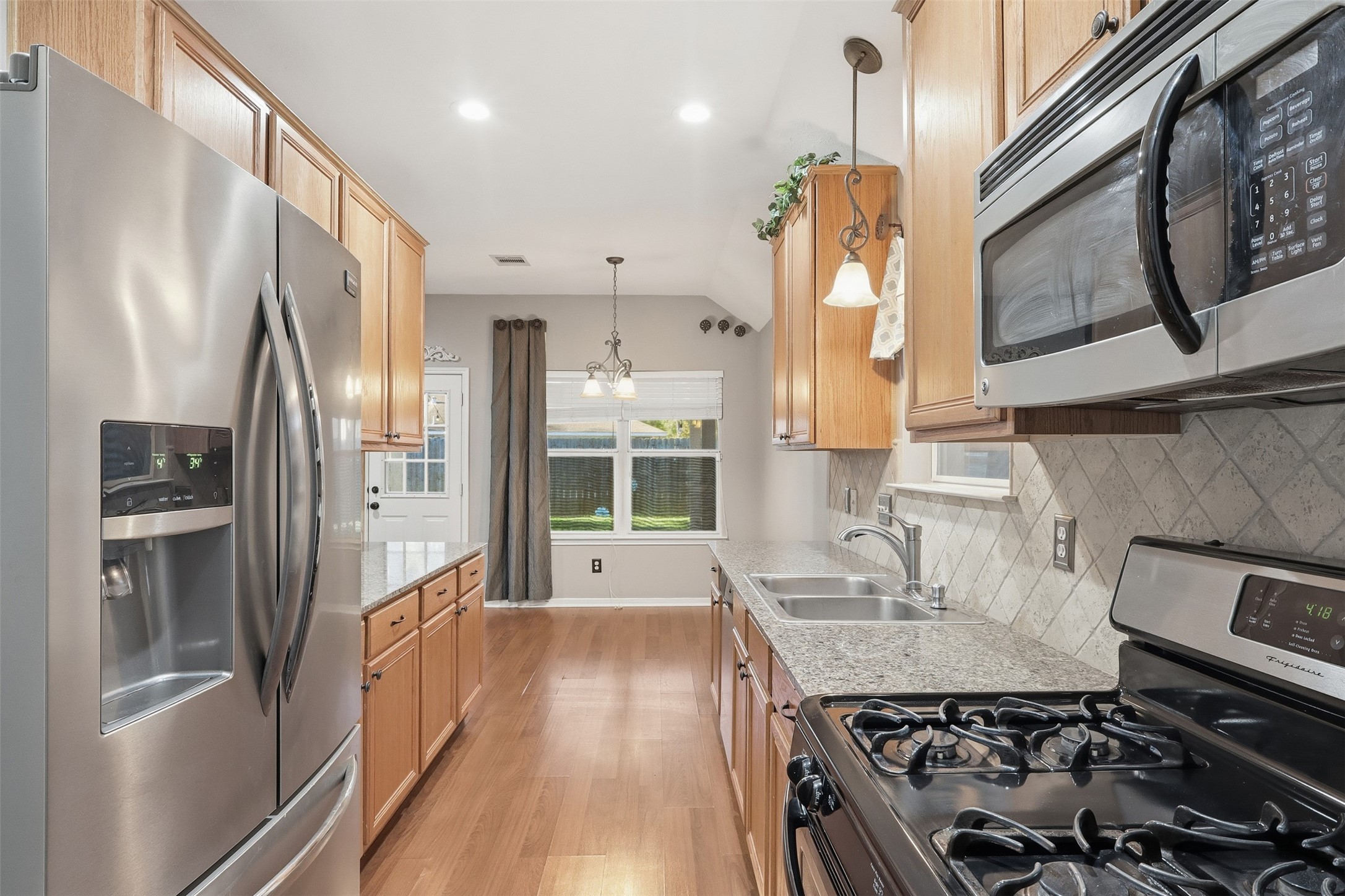 17423 Morning Star Avenue Crosby, TX 77532 - Photo 6 of 23 a kitchen with stainless steel appliances a stove a sink and a refrigerator