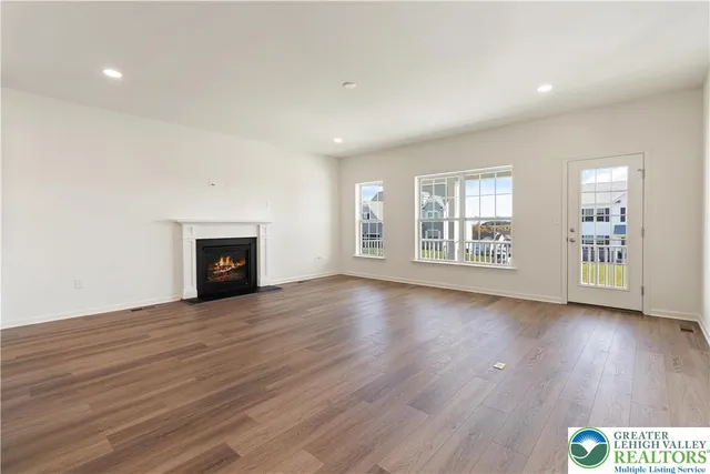 an empty room with wooden floor and fireplace