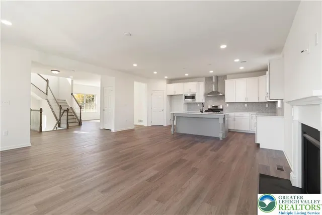 a view of kitchen with granite countertop stainless steel appliances refrigerator sink and cabinets