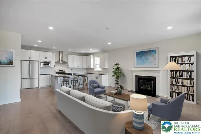 a living room with furniture a fireplace and a kitchen view